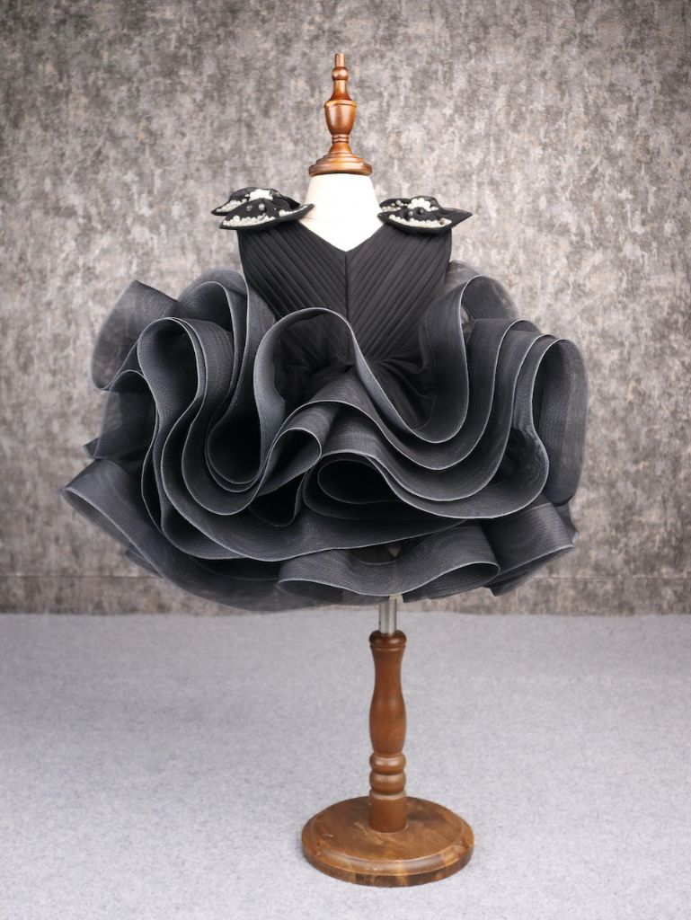 Black couture party dress for girls with pearl embellished shoulder bows and dramatic layered ruffle skirt