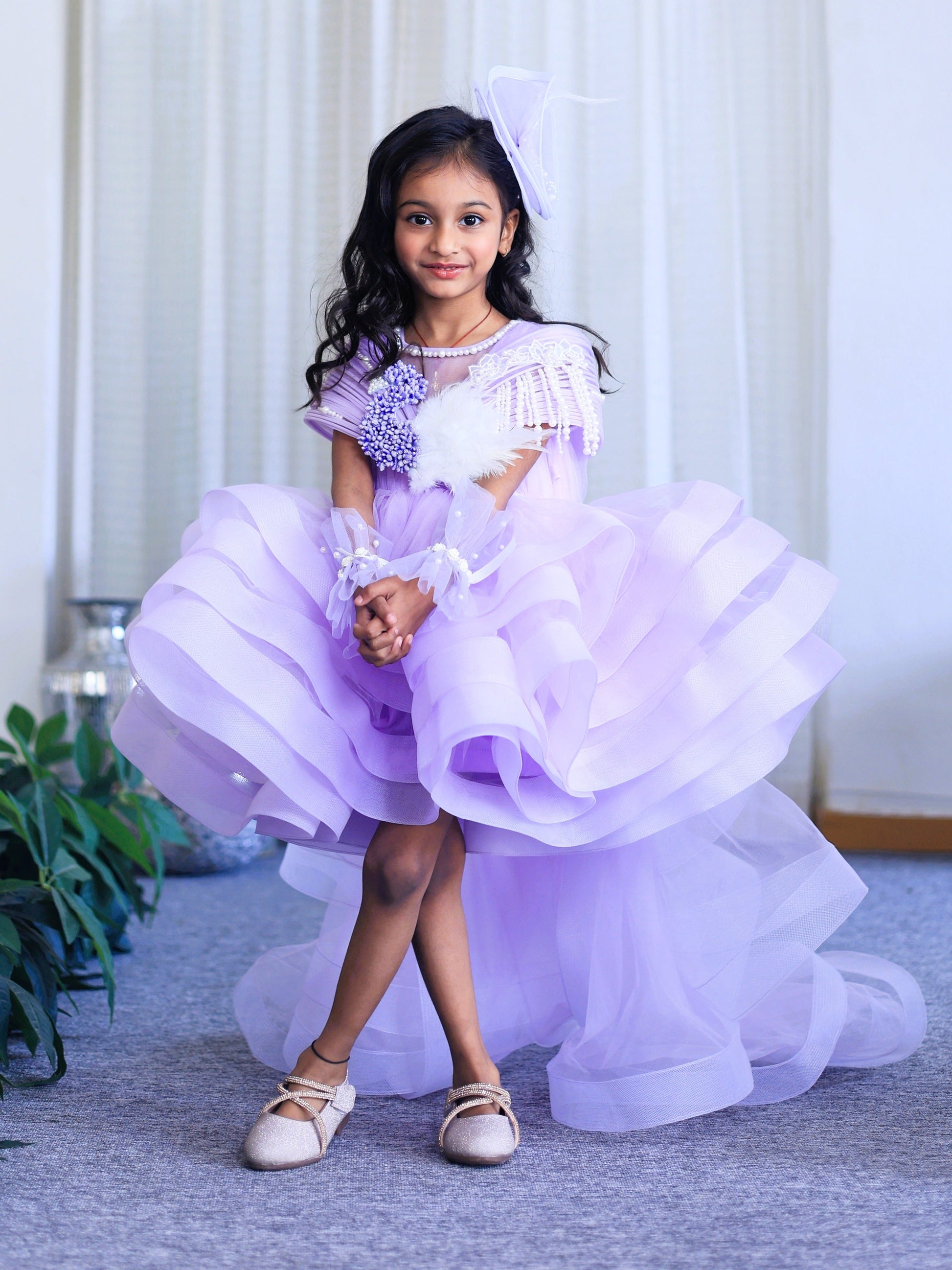 Lavender layered couture dress for girls with structured shoulders, pearl embellishments and dramatic ruffle flare